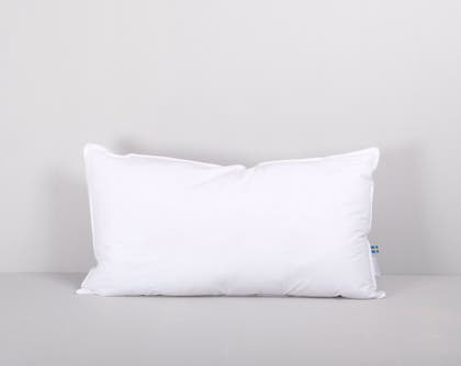 Vit lång kudde mot en ljusgrå bakgrund.